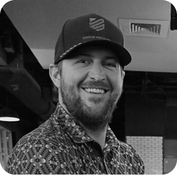 ADN team member headshot, black and white portrait wearing a branded cap